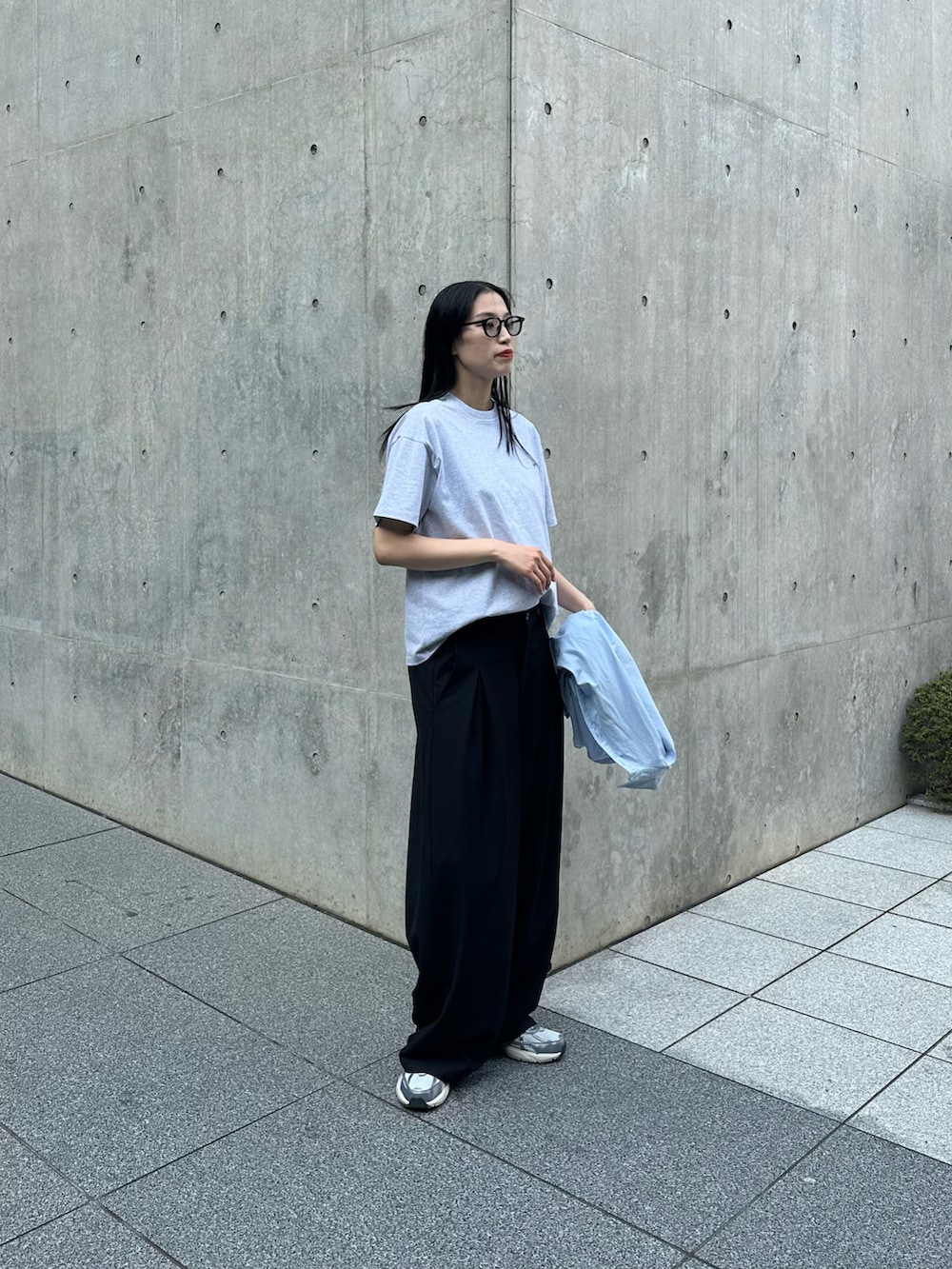 グレー系のTシャツ/カットソー、ブルー系のシャツ/ブラウス、ブラック系のスラックスを着用したレディースの春コーディネートの2枚目の写真