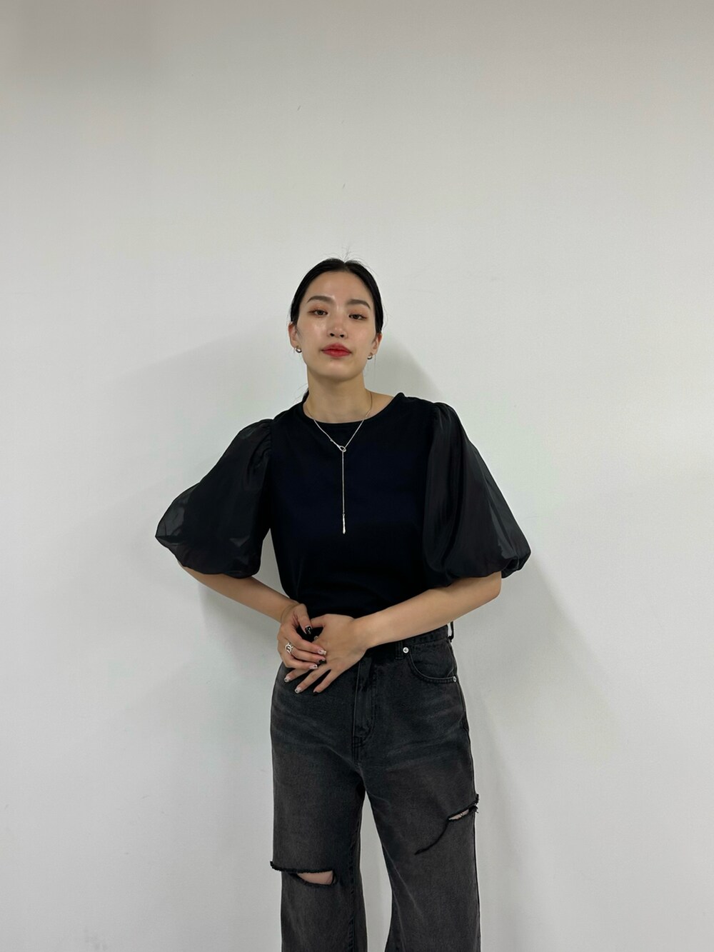 ブラック系のデニムパンツ、ブラック系のサンダル、ブラック系のTシャツ/カットソーを着用したレディースの夏コーディネートの3枚目の写真