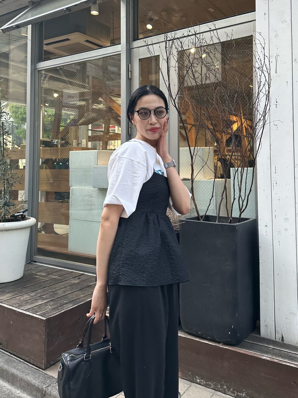 ブラック系のその他パンツ、ブラック系のキャミソール、ホワイト系のTシャツ/カットソーを着用したレディースの春コーディネートの3枚目の写真