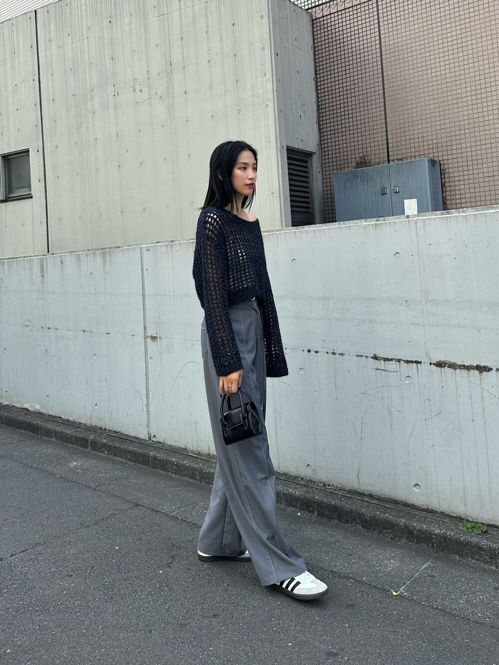 ブルー系のニット/セーター、ブラック系のショルダーバッグを着用したレディースの夏コーディネートの4枚目の写真