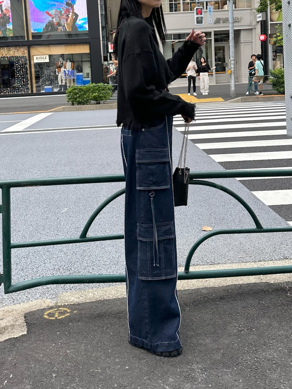 ブラック系のブーツ、ブルー系のデニムパンツ、ブラック系のニット/セーターを着用したレディースの秋コーディネートの3枚目の写真