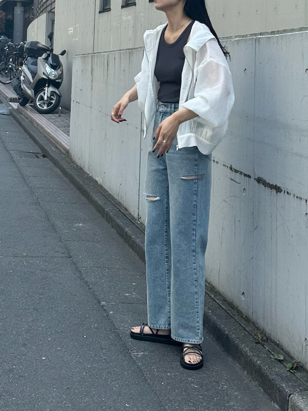 ブラック系のサンダル、ブルー系のデニムパンツ、ホワイト系のシャツ/ブラウスを着用したレディースの春コーディネートの3枚目の写真