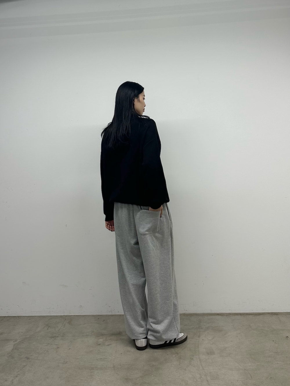 ブラック系のニット/セーター、グレー系のスウェットパンツを着用したレディースの秋コーディネートの4枚目の写真