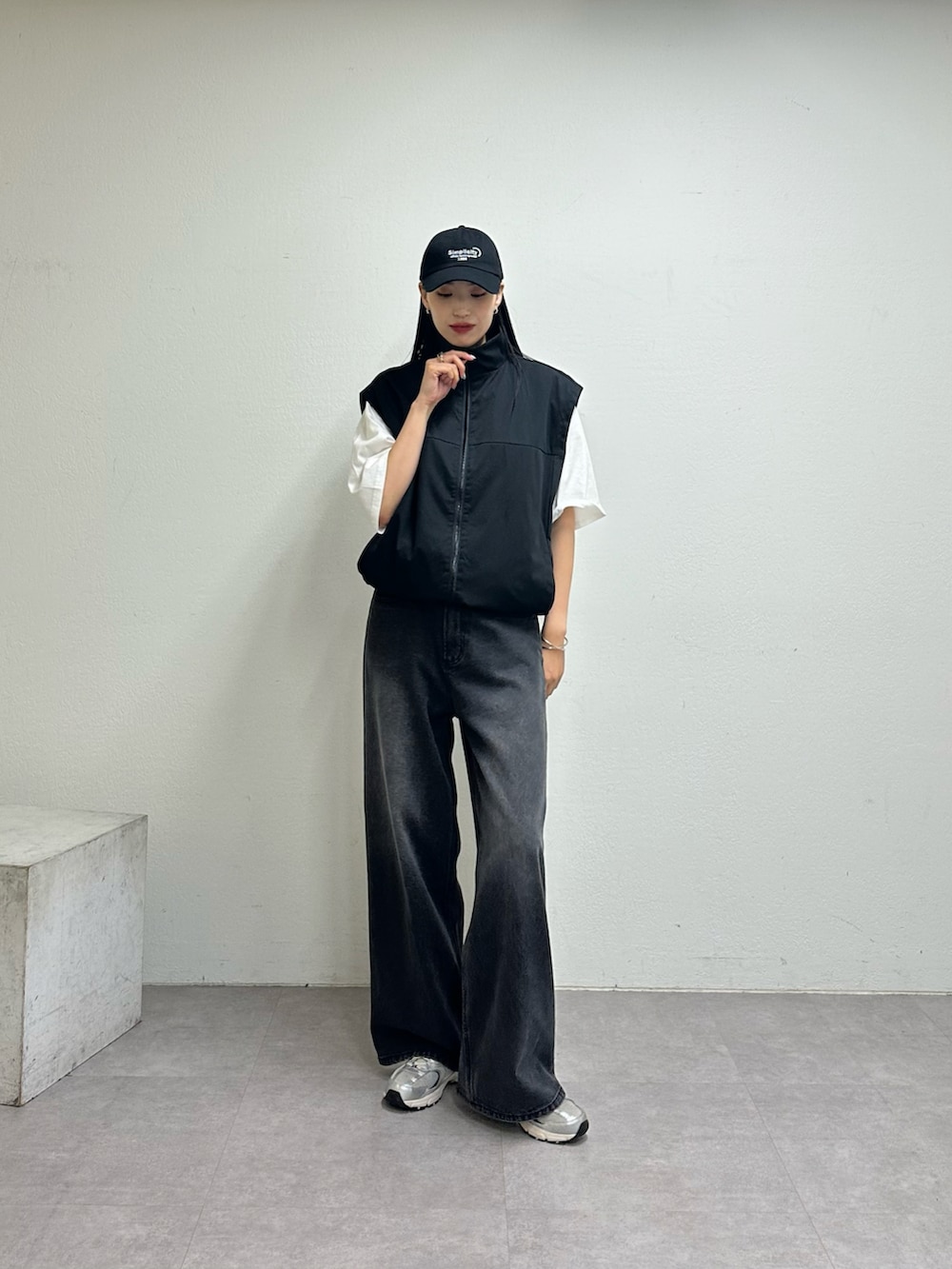 ブラック系のベスト、ホワイト系のTシャツ/カットソー、ブラック系のデニムパンツを着用したレディースの夏コーディネートの4枚目の写真