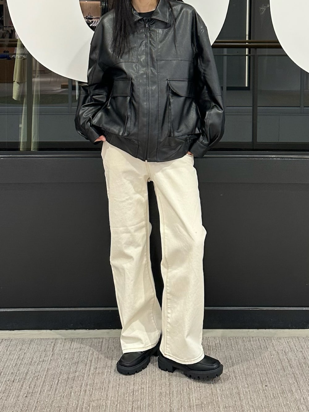 ホワイト系のデニムパンツ、ブラック系のブルゾンを着用したレディースの冬コーディネートの4枚目の写真