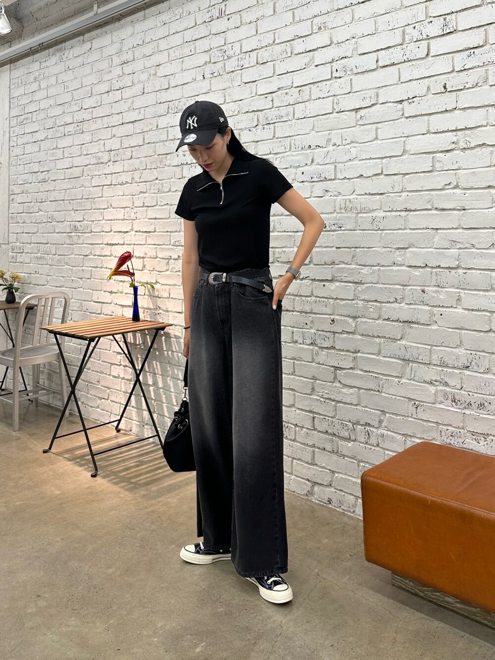 ブラック系のTシャツ/カットソー、ブラック系のデニムパンツ、ブラック系のベルトを着用したレディースの夏コーディネートの2枚目の写真