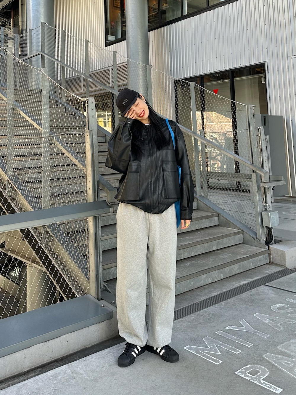 ブラック系のブルゾン、ブルー系のトートバッグを着用したレディースの冬コーディネートの4枚目の写真