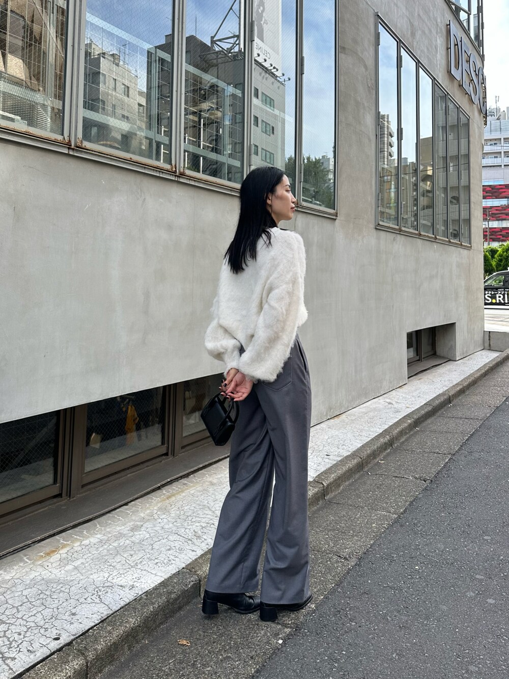 グレー系のその他パンツ、ホワイト系のニット/セーター、ブラック系のショルダーバッグを着用したレディースの秋コーディネートの3枚目の写真