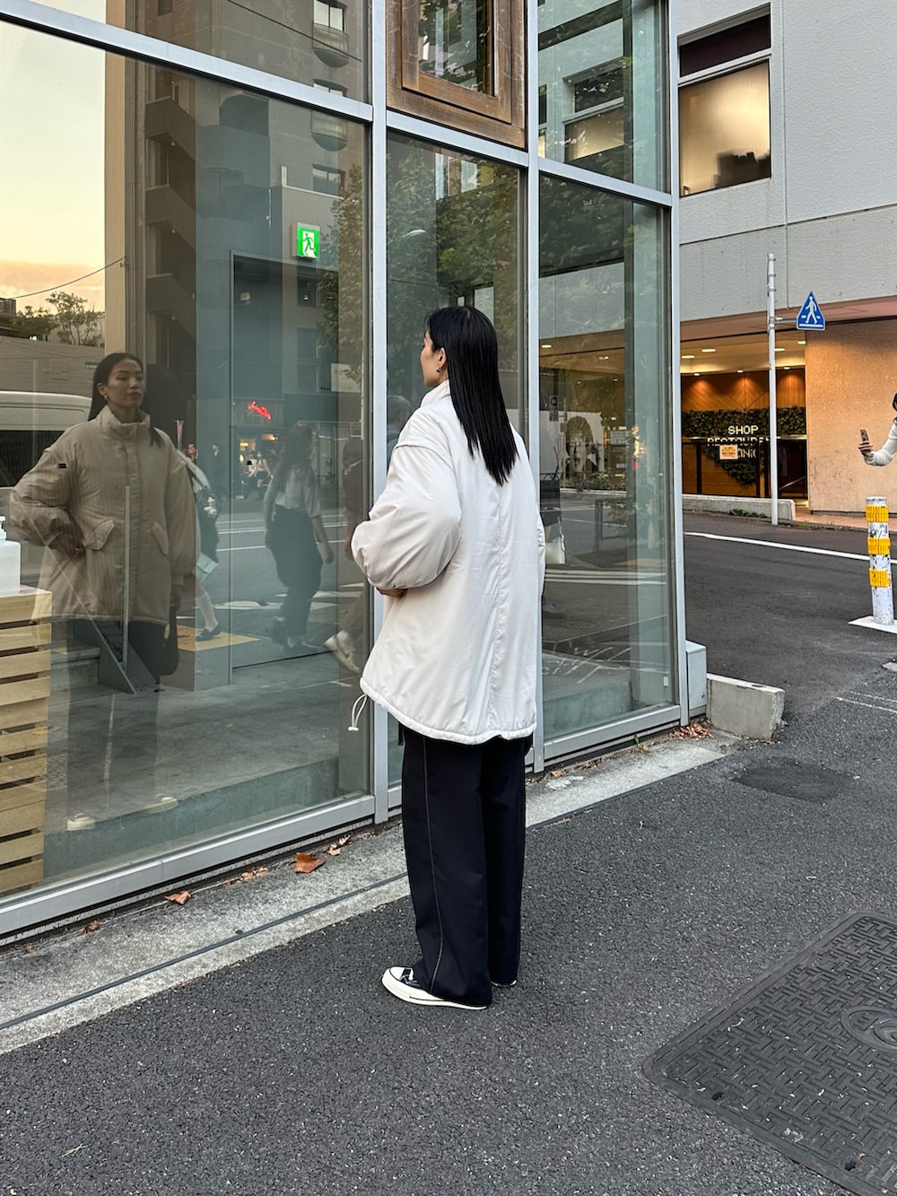 ブラック系のその他パンツ、ホワイト系のダウンジャケット/コート、ブラック系のショルダーバッグを着用したレディースの秋コーディネートの2枚目の写真