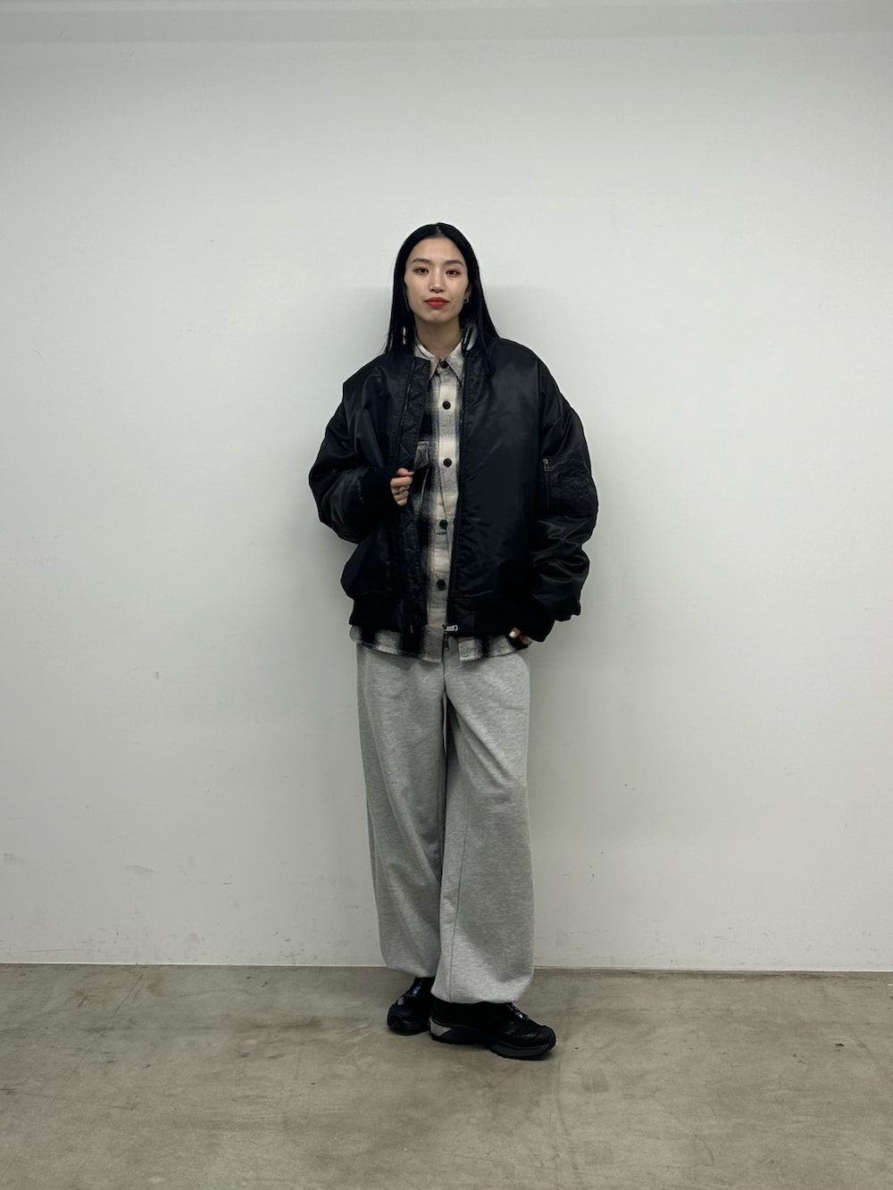 ブラック系のトップス、ブラック系のMA-1、グレー系のスウェットパンツを着用したレディースの秋コーディネートの4枚目の写真