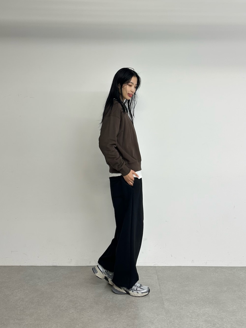 ブラウン系のスウェット、ブラック系のスウェットパンツを着用したレディースの冬コーディネートの3枚目の写真