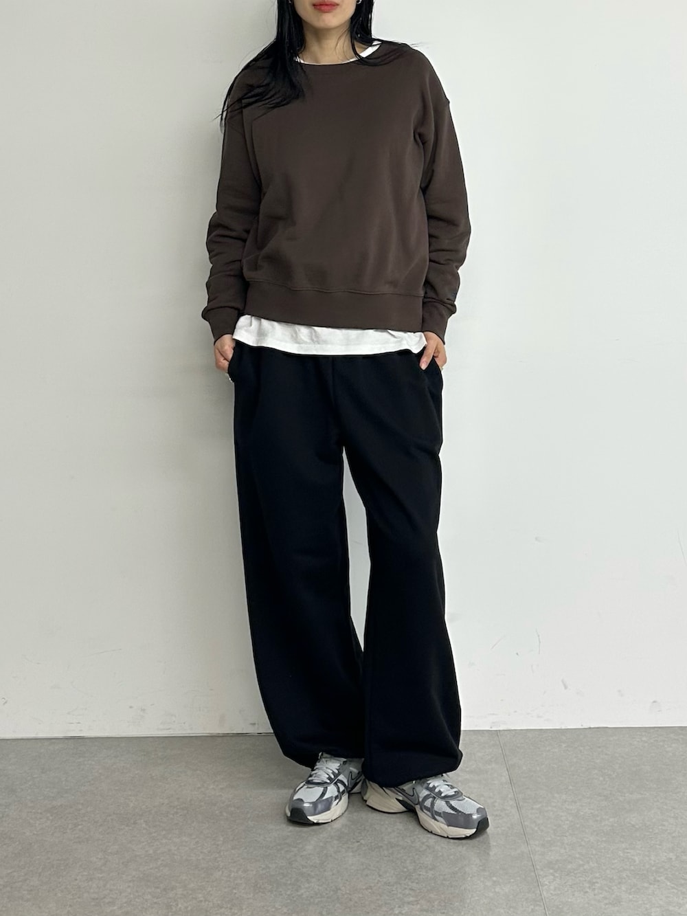 ブラウン系のスウェット、ブラック系のスウェットパンツを着用したレディースの冬コーディネートの4枚目の写真