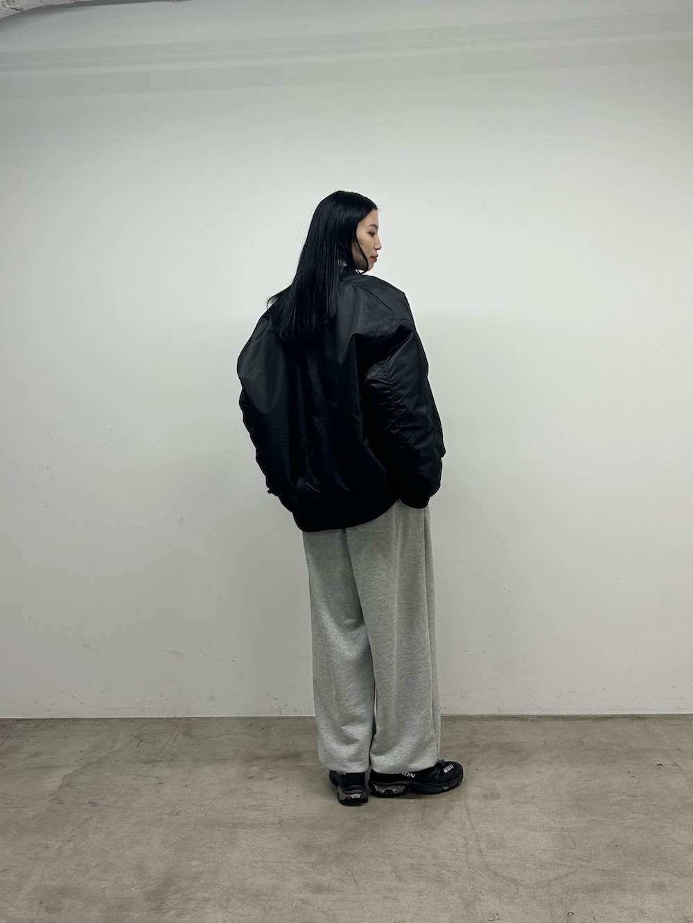 ブラック系のトップス、ブラック系のMA-1、グレー系のスウェットパンツを着用したレディースの秋コーディネートの3枚目の写真