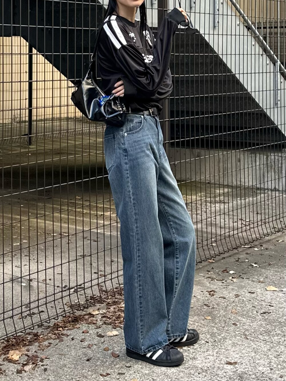 ブルー系のデニムパンツ、ブラック系のTシャツ/カットソー、グレー系のニットキャップ/ビーニーを着用したレディースの秋コーディネートの4枚目の写真