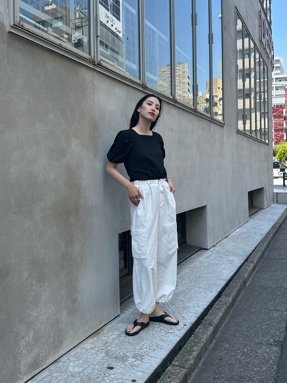 ブラック系のシャツ/ブラウス、ホワイト系のカーゴパンツ、ブラック系のサンダルを着用したレディースの春コーディネートの2枚目の写真