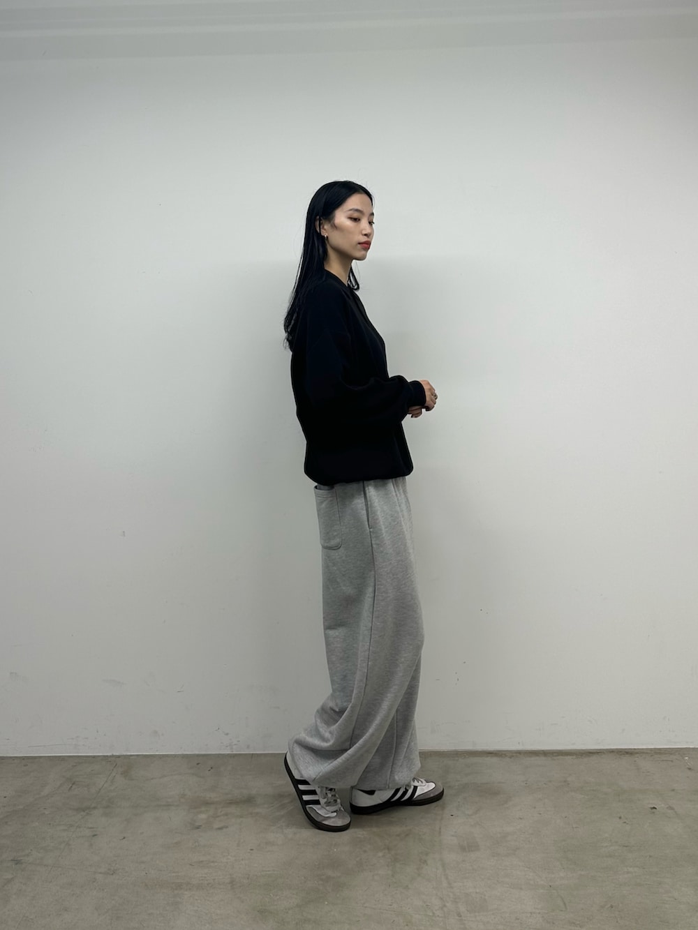 ブラック系のニット/セーター、グレー系のスウェットパンツを着用したレディースの秋コーディネートの3枚目の写真