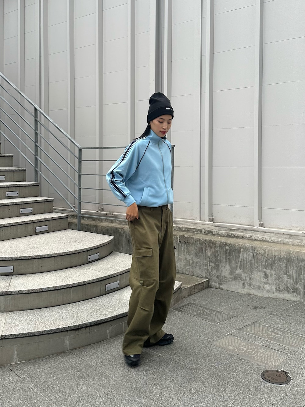 グリーン系のカーゴパンツ、ブルー系のジャケット/アウター、ブラック系のニットキャップ/ビーニーを着用したレディースの秋コーディネートの2枚目の写真