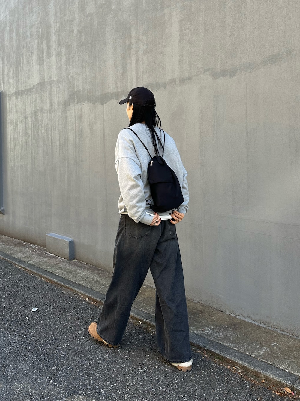 ブラック系のデニムパンツ、ブラック系のバックパック/リュックを着用したレディースの秋コーディネートの3枚目の写真