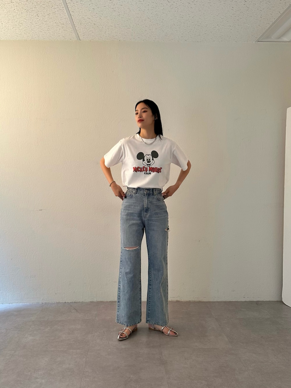 ブルー系のデニムパンツ、シルバー系のサンダル、ホワイト系のTシャツ/カットソーを着用したレディースの夏コーディネートの2枚目の写真