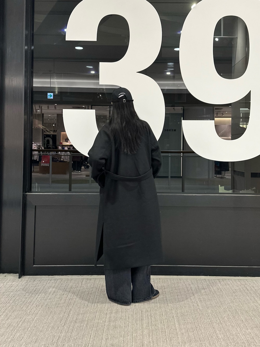 ブラック系のその他アウター、ホワイト系のTシャツ/カットソー、グレー系のニット/セーターを着用したレディースの冬コーディネートの3枚目の写真