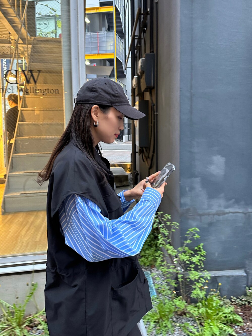 ブラック系のパンツ、ブラック系のスニーカー、ブルー系のシャツ/ブラウスを着用したレディースの春コーディネートの3枚目の写真