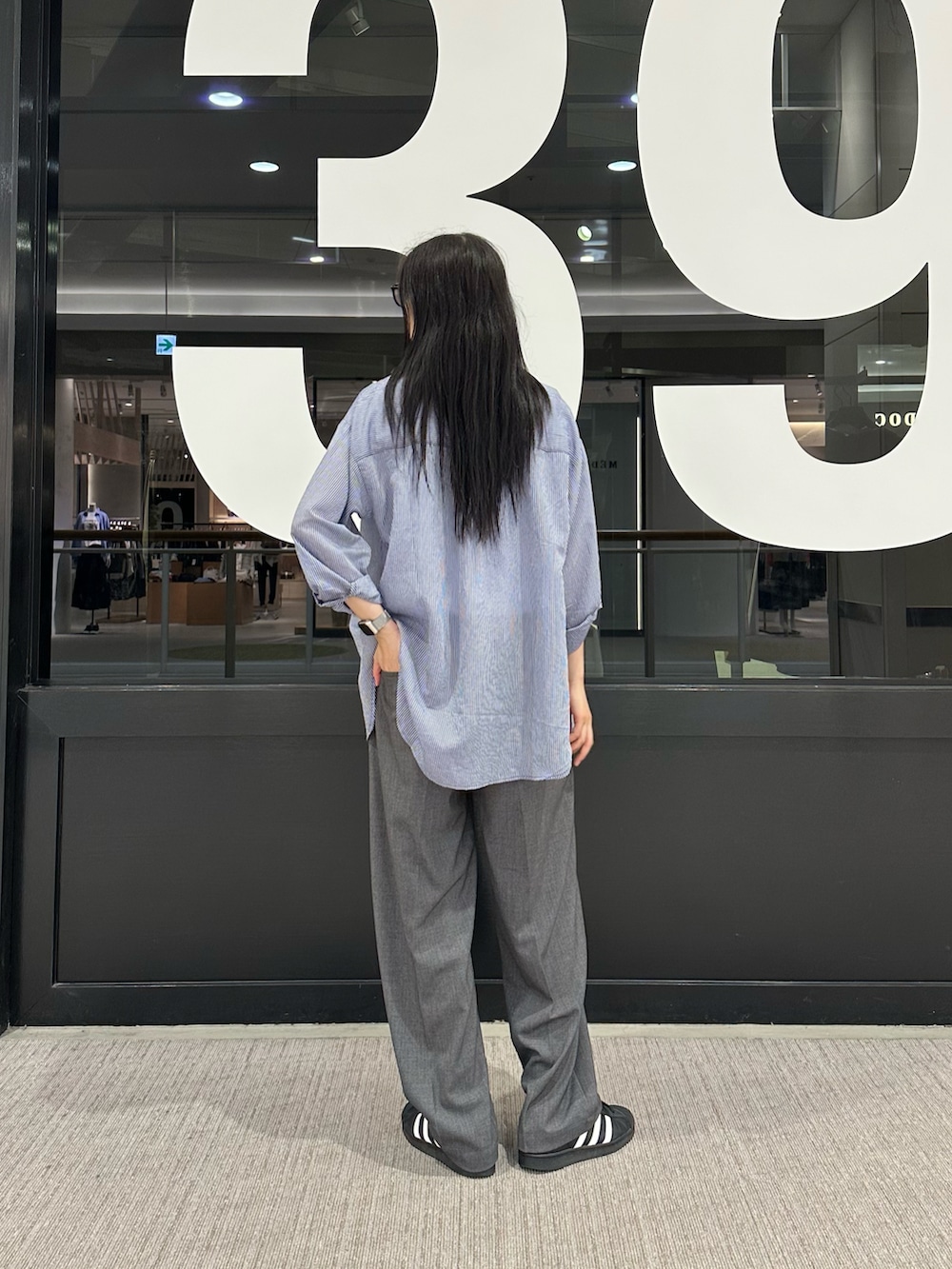 ブルー系のシャツ/ブラウス、ホワイト系のTシャツ/カットソー、グレー系のスラックスを着用したレディースの春コーディネートの3枚目の写真