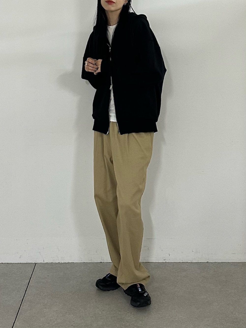 ベージュ系のその他パンツ、ブラック系のパーカーを着用したレディースの秋コーディネートの2枚目の写真