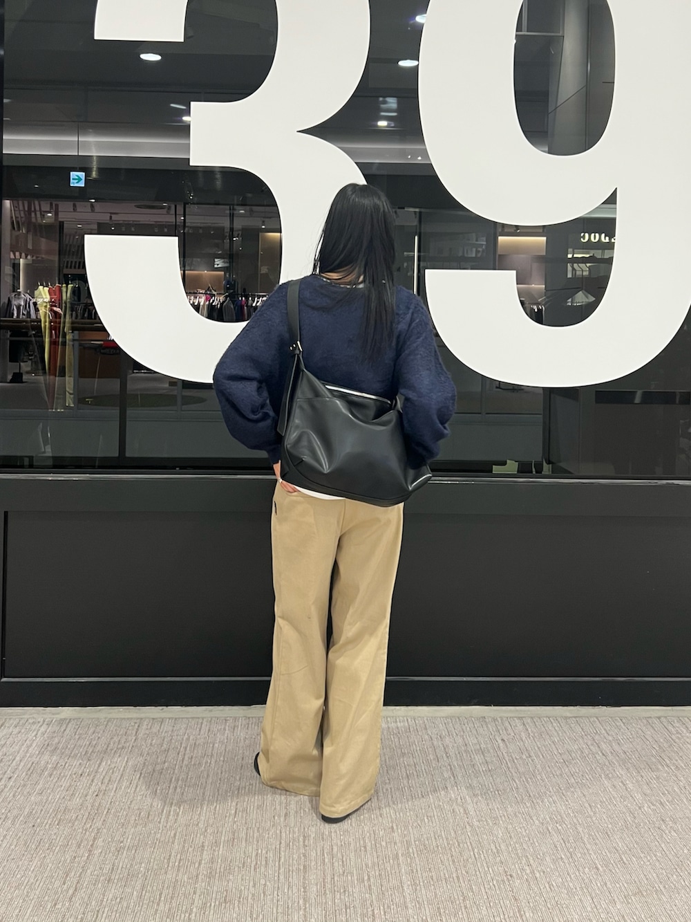 ベージュ系のその他パンツ、ブルー系のニット/セーター、ホワイト系のTシャツ/カットソーを着用したレディースの秋コーディネートの3枚目の写真