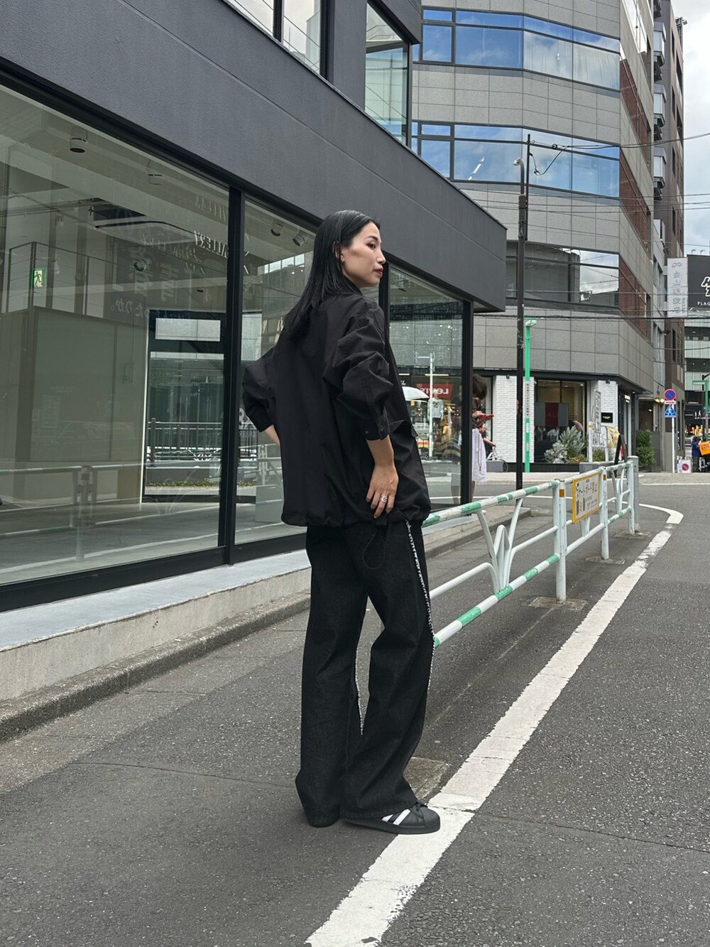 ブラック系のデニムパンツ、ブラック系のブルゾン、ホワイト系のTシャツ/カットソーを着用したレディースの夏コーディネートの2枚目の写真