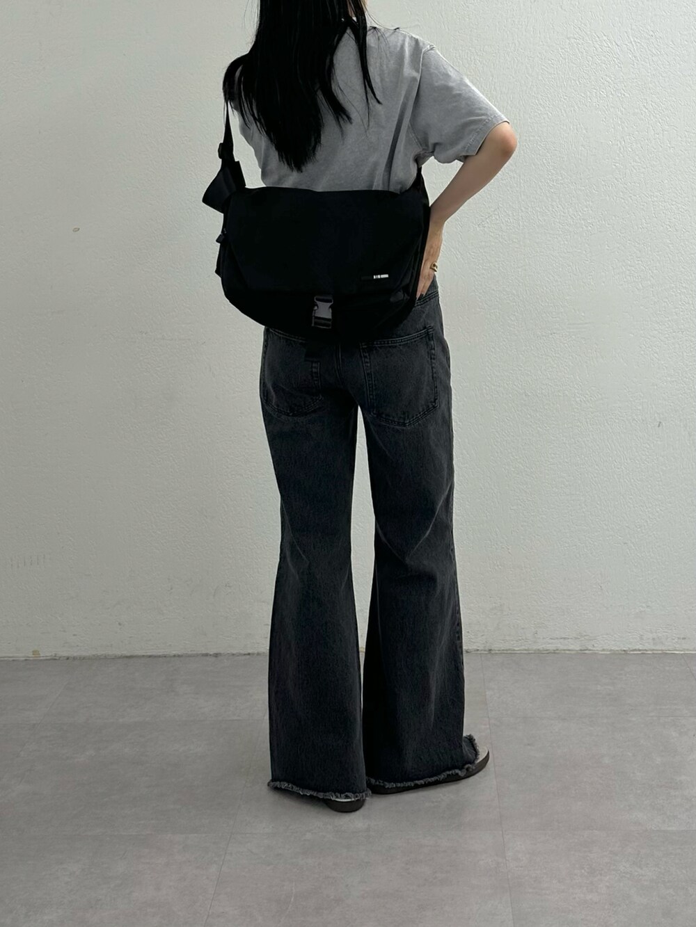 ブラック系のデニムパンツ、グレー系のTシャツ/カットソー、ブラック系のショルダーバッグを着用したレディースの夏コーディネートの4枚目の写真