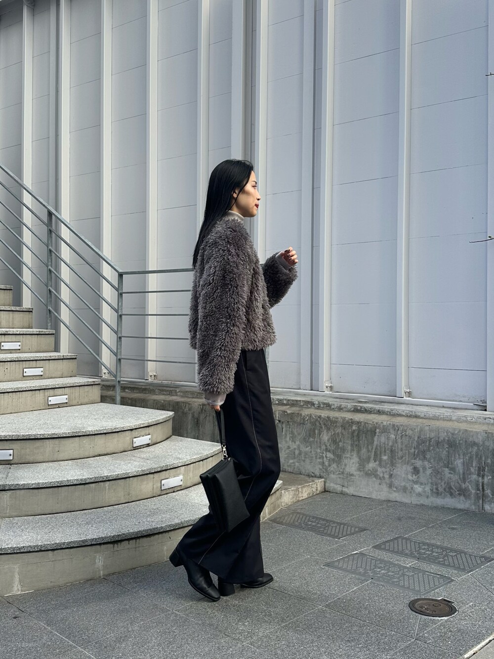 ブラック系のショルダーバッグ、ブラック系のその他パンツ、グレー系のTシャツ/カットソーを着用したレディースの冬コーディネートの2枚目の写真