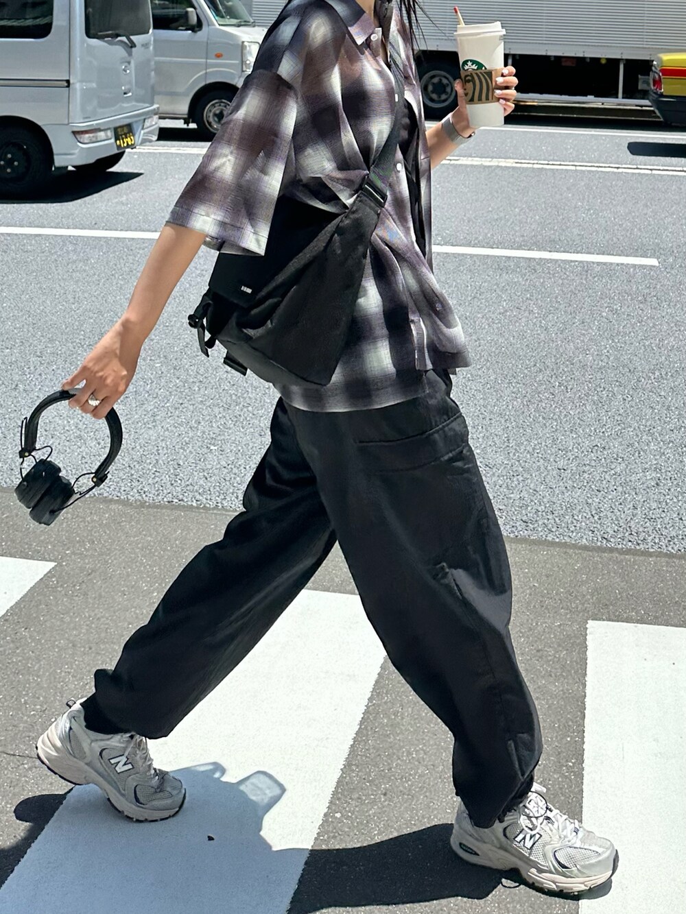 ブラック系のカーゴパンツ、ブラック系のメッセンジャーバッグ、ブラック系のシャツ/ブラウスを着用したレディースの春コーディネートの4枚目の写真