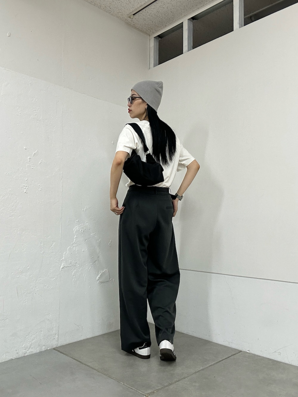 ホワイト系のTシャツ/カットソー、グレー系のスラックス、ブラック系のショルダーバッグを着用したレディースの夏コーディネートの3枚目の写真