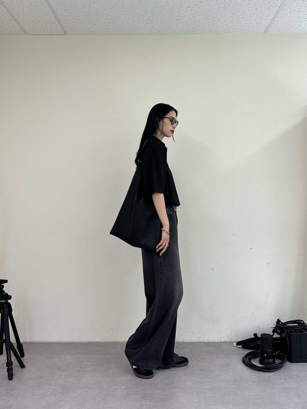 ブラック系のデニムパンツ、ブラック系のTシャツ/カットソー、ブラック系のトートバッグを着用したレディースの夏コーディネートの2枚目の写真