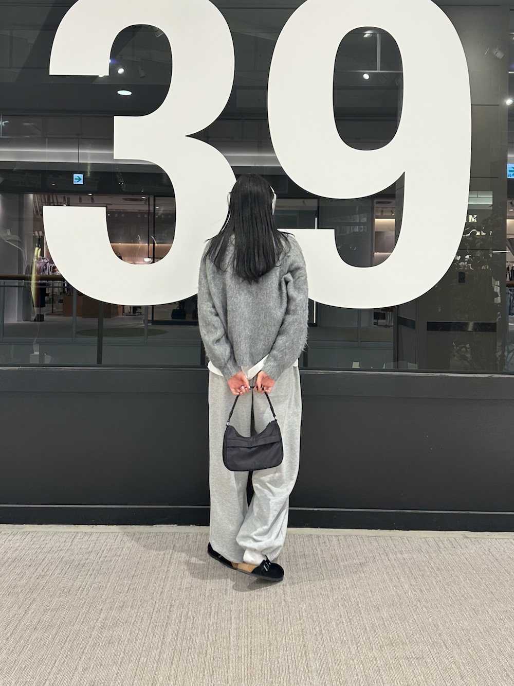 グレー系のカーディガン/ボレロ、ホワイト系のTシャツ/カットソー、グレー系のスウェットパンツを着用したレディースの冬コーディネートの3枚目の写真