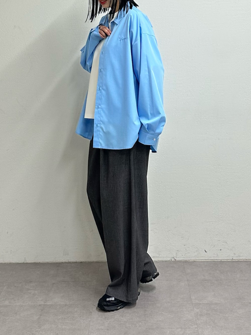 ホワイト系のTシャツ/カットソー、ブルー系のシャツ/ブラウス、グレー系のスラックスを着用したレディースの春コーディネートの2枚目の写真