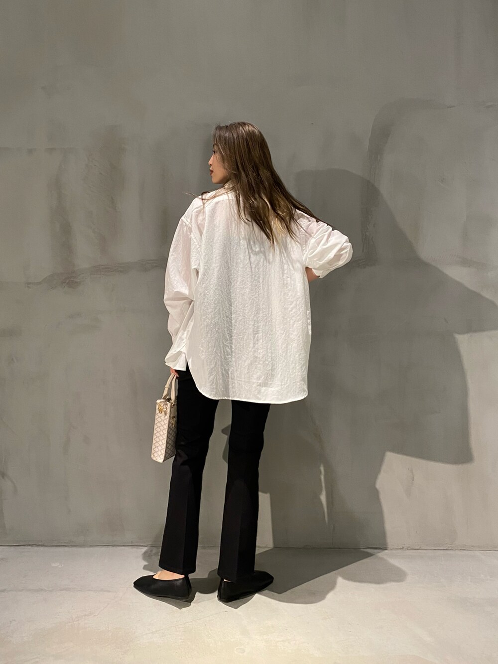 ブラック系のパンプス、ブラック系のその他パンツ、ホワイト系のトートバッグを着用したレディースの春コーディネートの2枚目の写真