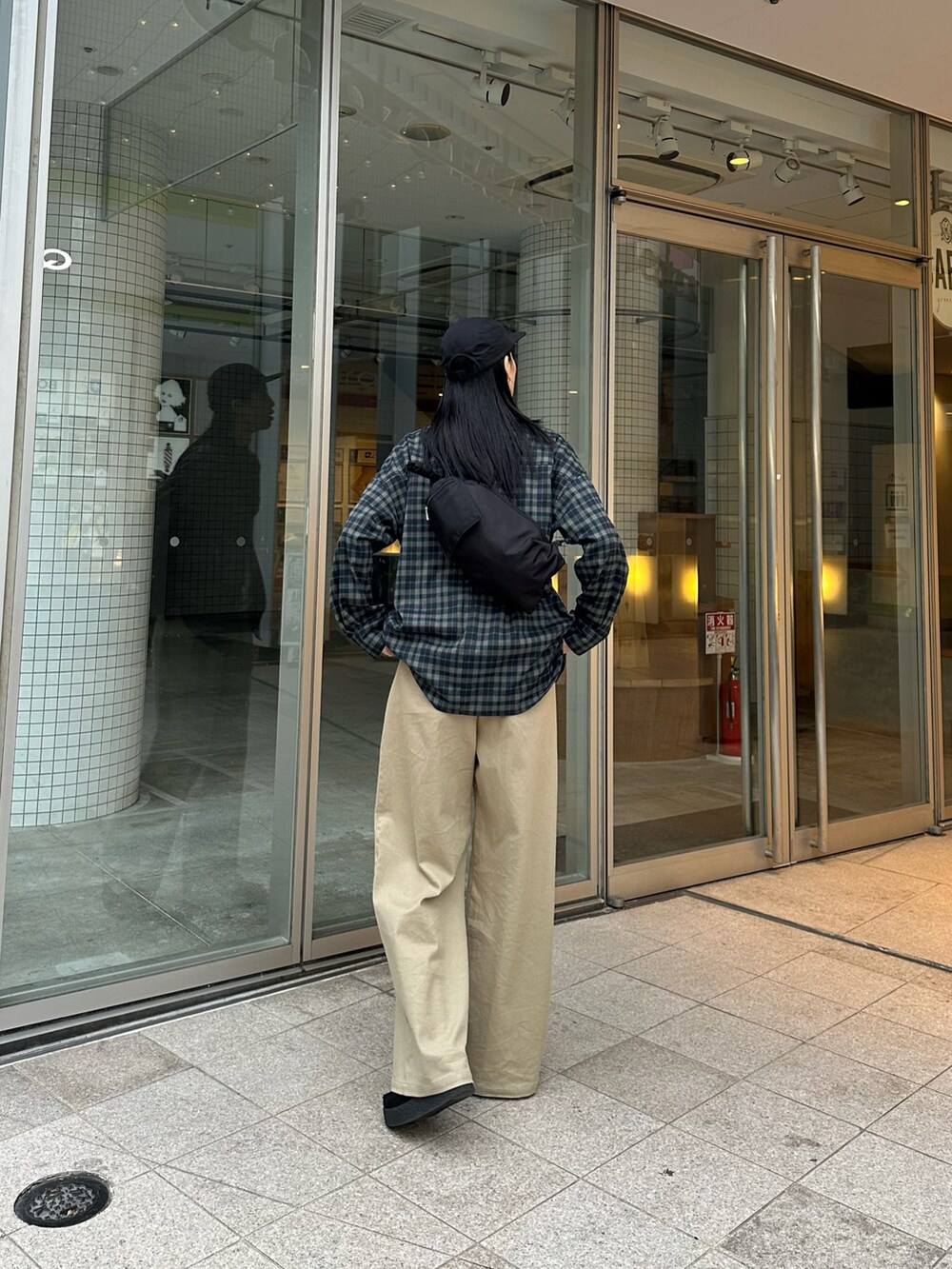 ブルー系のシャツ/ブラウス、ベージュ系のスラックス、ブラック系のモカシン/デッキシューズを着用したレディースの冬コーディネートの2枚目の写真