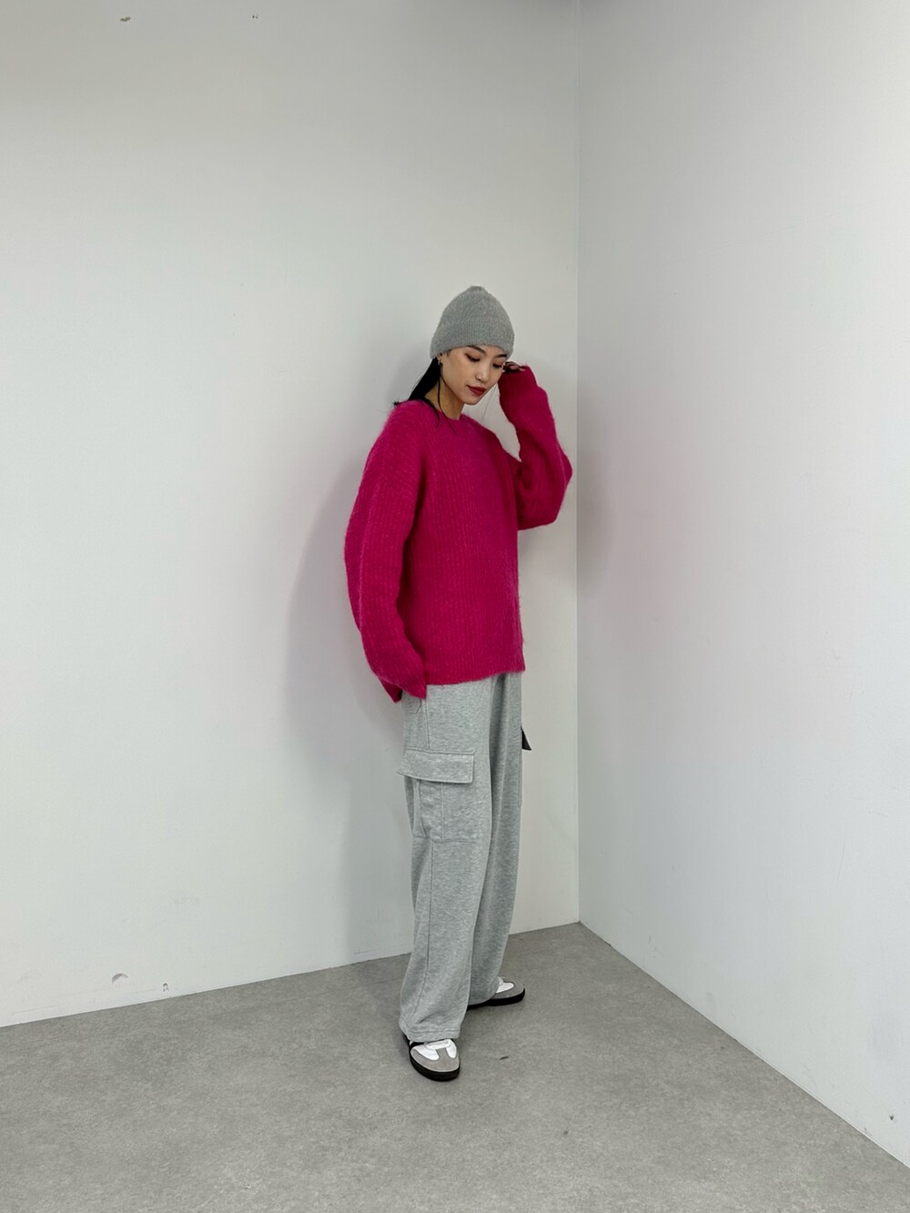 グレー系のカーゴパンツ、ピンク系のニット/セーター、グレー系のニットキャップ/ビーニーを着用したレディースの秋コーディネートの3枚目の写真