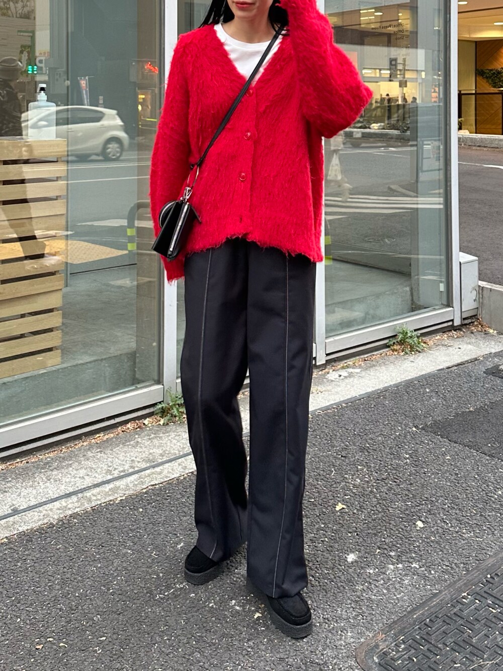 レッド系のカーディガン/ボレロ、ブラック系のその他パンツ、ブラック系のモカシン/デッキシューズを着用したレディースの冬コーディネートの4枚目の写真