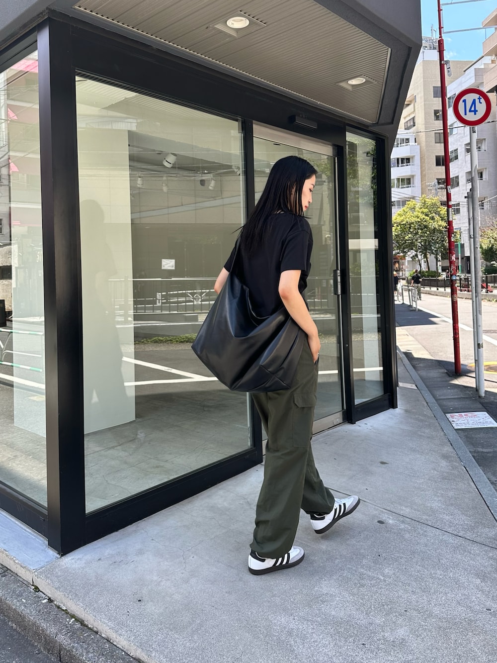 グリーン系のカーゴパンツ、ブラック系のTシャツ/カットソー、ブラック系のショルダーバッグを着用したレディースの夏コーディネートの3枚目の写真