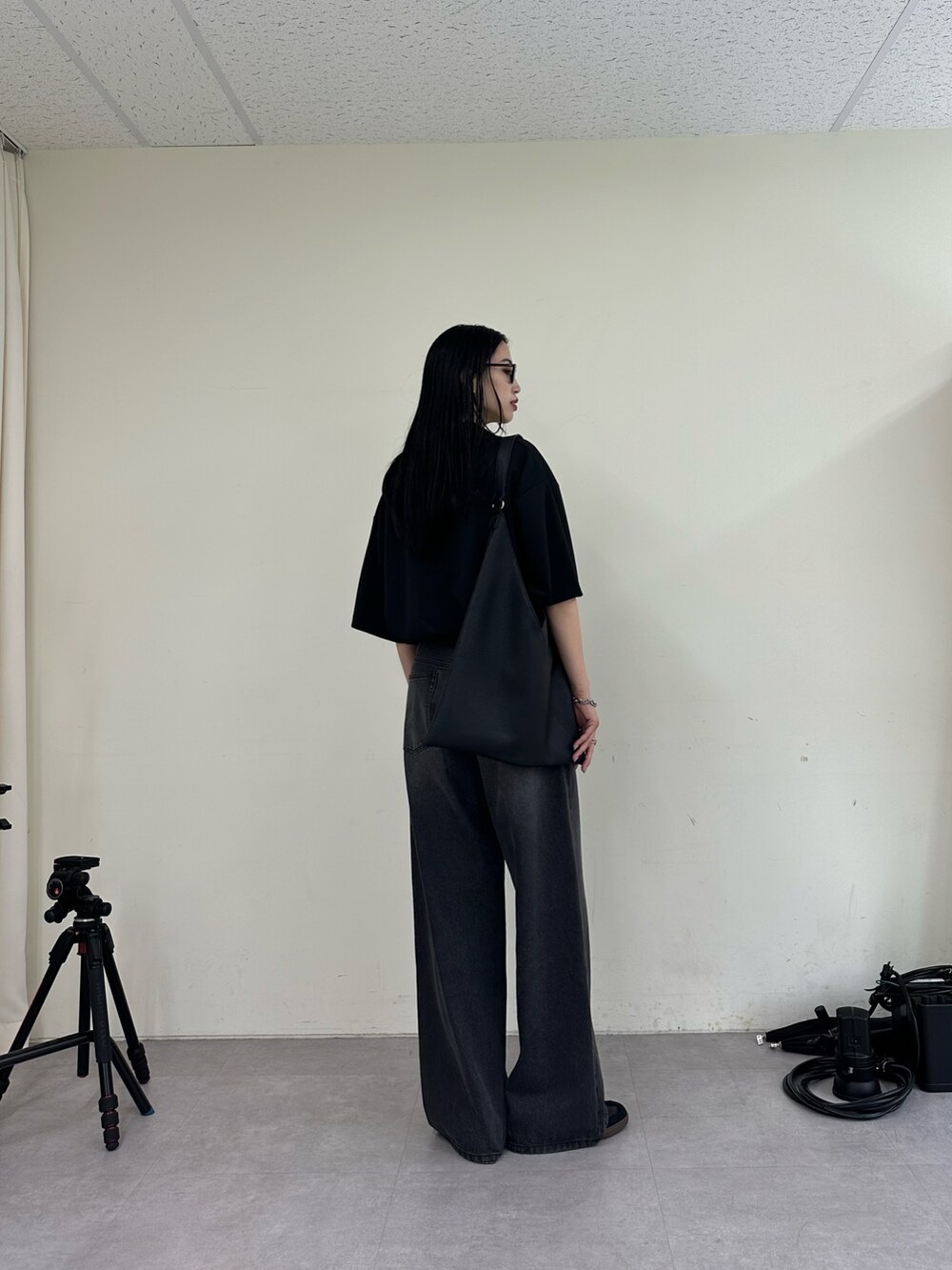 ブラック系のデニムパンツ、ブラック系のTシャツ/カットソー、ブラック系のトートバッグを着用したレディースの夏コーディネートの3枚目の写真