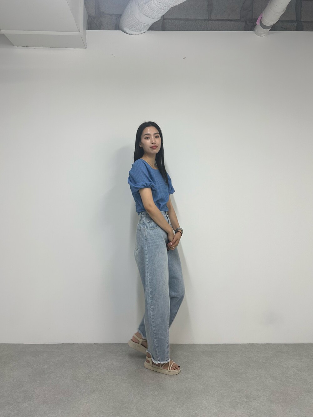 ブルー系のデニムパンツ、ベージュ系のサンダル、ブルー系のシャツ/ブラウスを着用したレディースの夏コーディネートの2枚目の写真