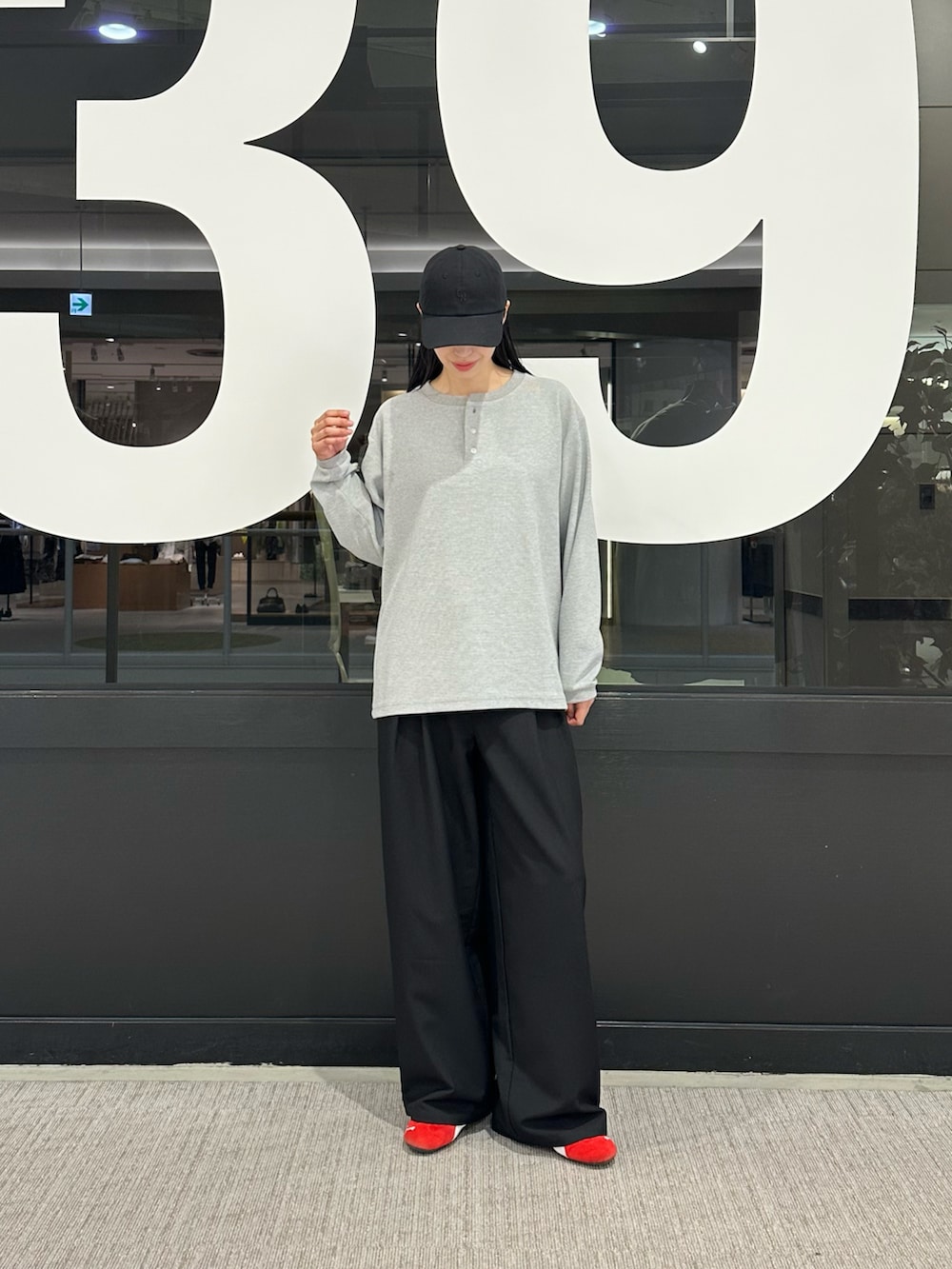 グレー系のTシャツ/カットソー、ブラック系のスラックス、ブラック系のキャップを着用したレディースの春コーディネートの4枚目の写真