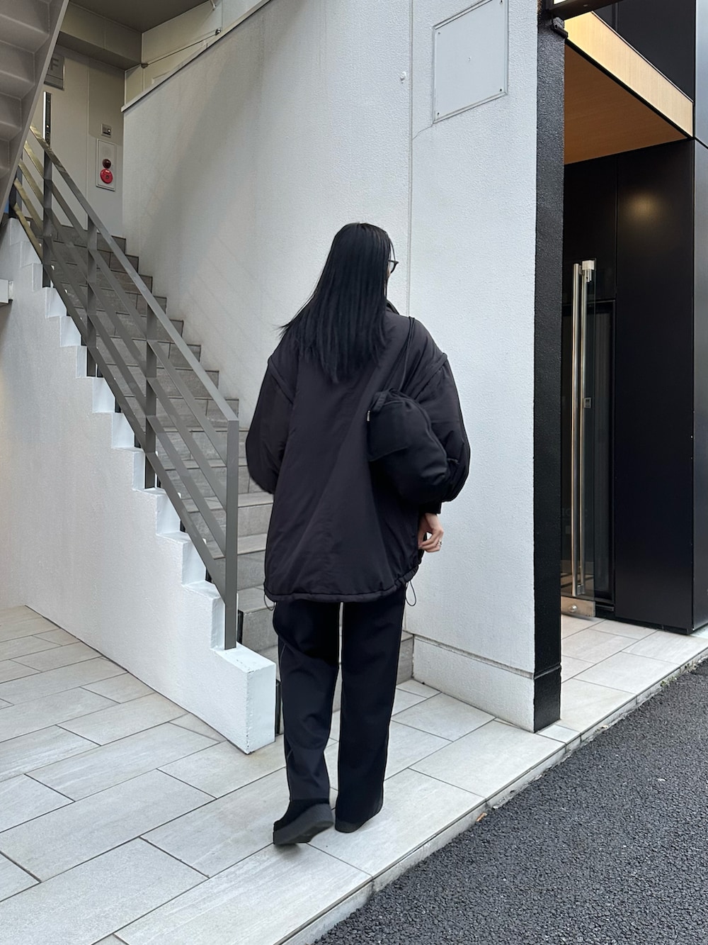 ブラック系のダウンジャケット/コート、ブルー系のシャツ/ブラウス、ブラック系のバックパック/リュックを着用したレディースの冬コーディネートの4枚目の写真