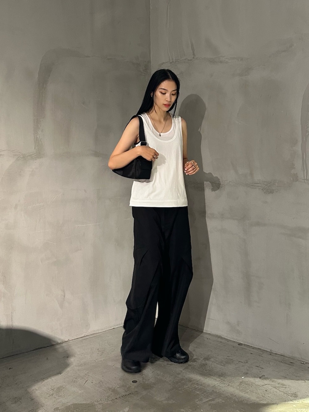 ホワイト系のタンクトップ、ブラック系のその他パンツ、ブラック系のショルダーバッグを着用したレディースの夏コーディネートの2枚目の写真
