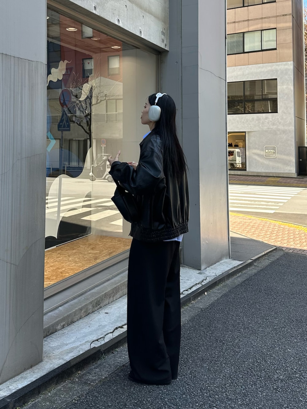 ブラック系のブルゾン、ブラック系のスラックス、ブラック系のハンドバッグを着用したレディースの冬コーディネートの3枚目の写真