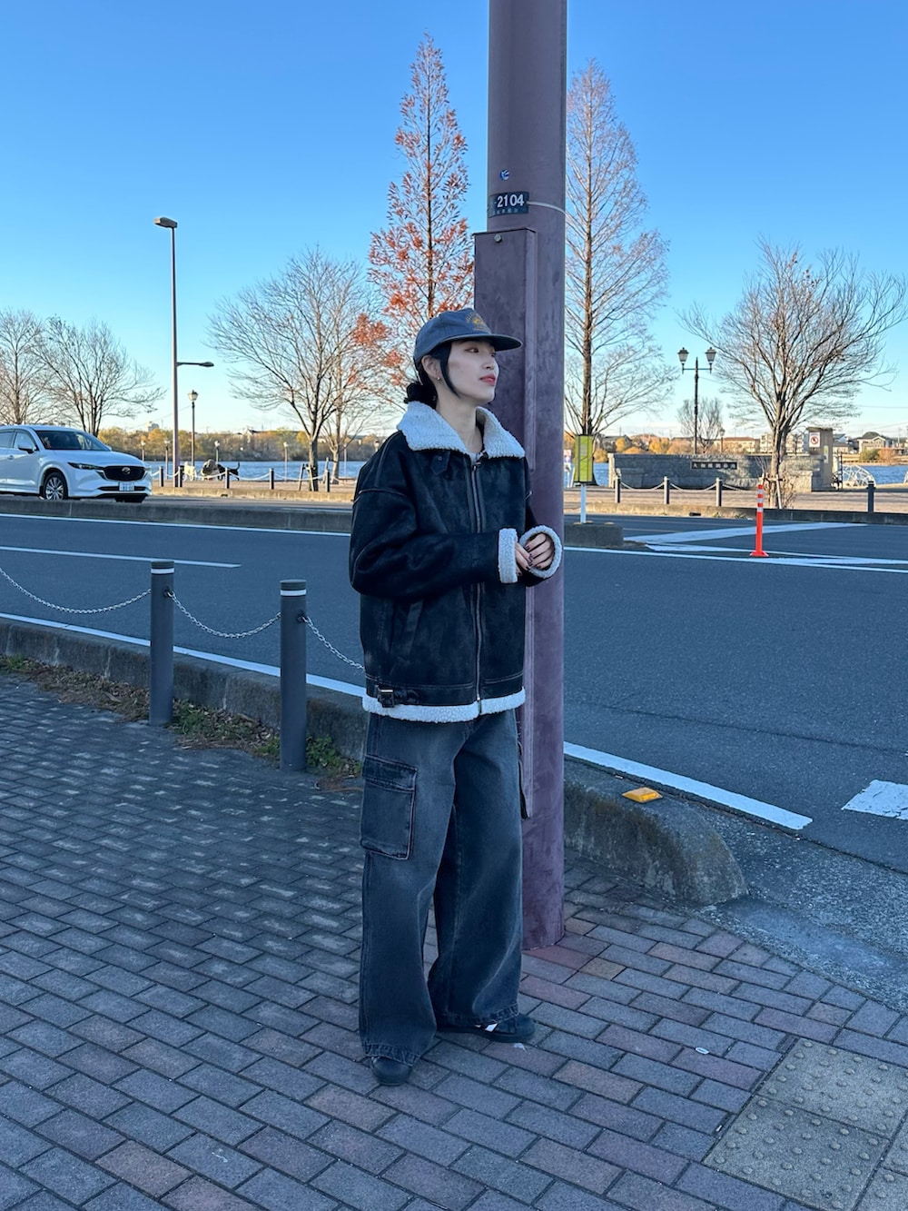 ブラック系のデニムパンツ、ブラック系のムートンコートを着用したレディースの冬コーディネートの2枚目の写真