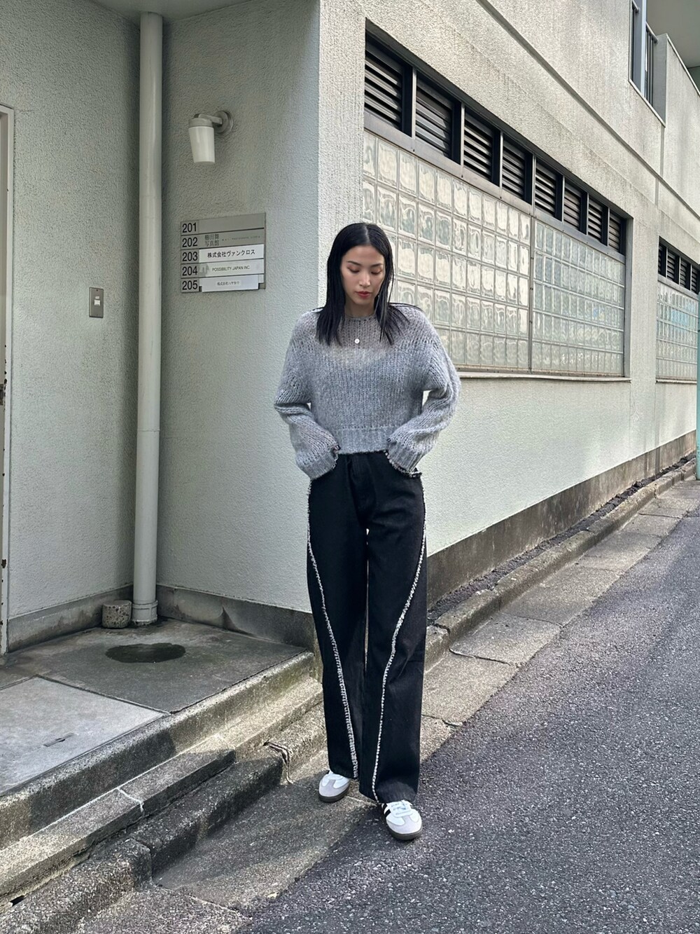 ブラック系のデニムパンツ、グレー系のニット/セーターを着用したレディースの夏コーディネートの3枚目の写真