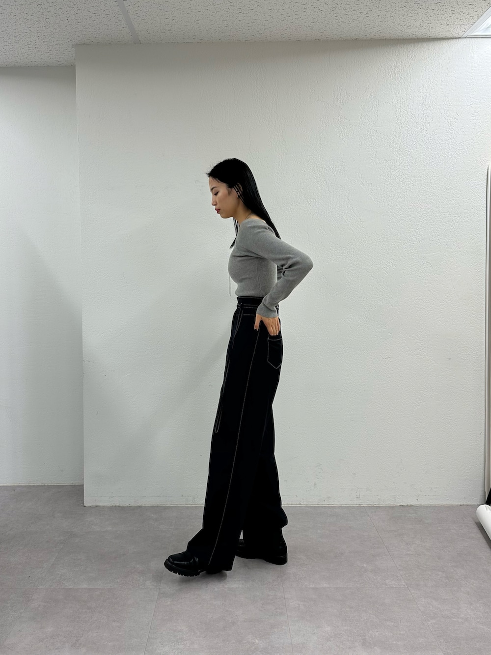 ブラック系のその他パンツ、グレー系のニット/セーター、ブラック系のブーツを着用したレディースの冬コーディネートの3枚目の写真